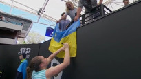 Ostapenko pēc uzvaras paraksta divus Ukrainas karogus