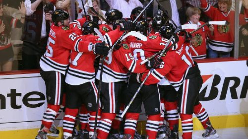 "Blackhawks" hokejisti metušies apskaut uzvaras vārtu autoru Brentu Sībruku. Foto:AFP/Scanpix