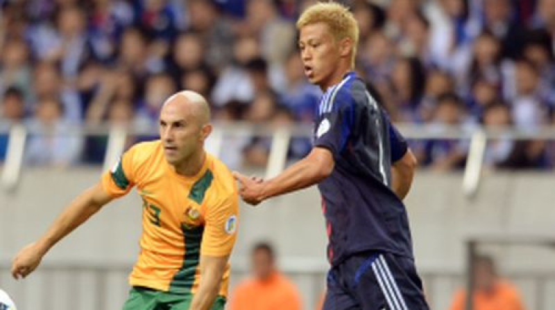 Austrālijas izlases pussargs Marks Bresciano un mača varonis Japānas rindās Keisuke Honda. Foto:AFP/Scanpix