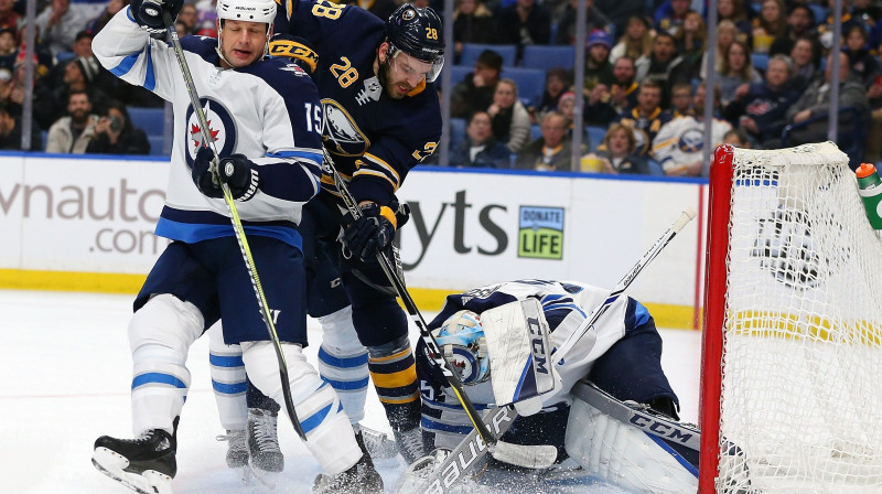 Zemgus Girgensons (centrā) cīņā vārtu priekšā 
Foto: AFP / Scanpix