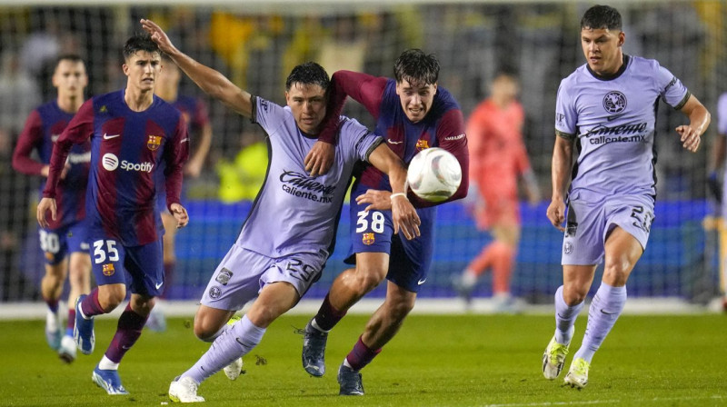 Ramons Huaress ("Club América") un Marks Guju ("Barcelona") cīņā par bumbu. Foto: Julio Cortez/AP/Scanpix