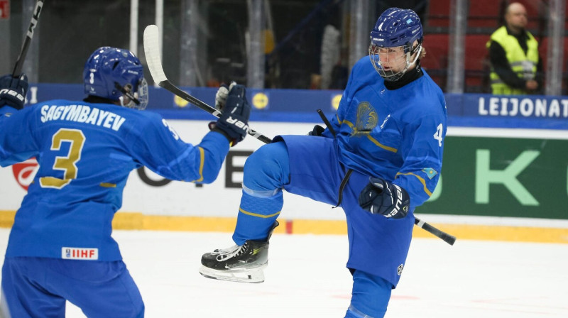 Kazahstānas U18 valstsvienības hokejisti Romāns Boļšedvorskis (Nr. 4) un Marats Sagimbajevs (Nr. 3). Foto: IIHF