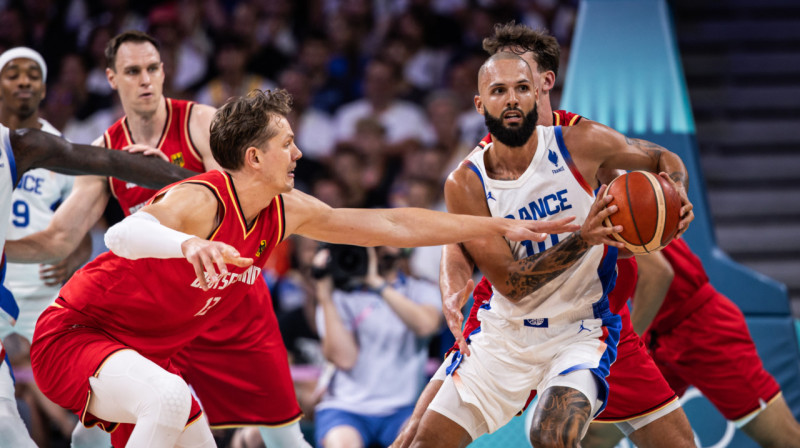 Evans Furnjē Vācijas valstsvienības basketbolistu ielenkumā. Foto: FIBA